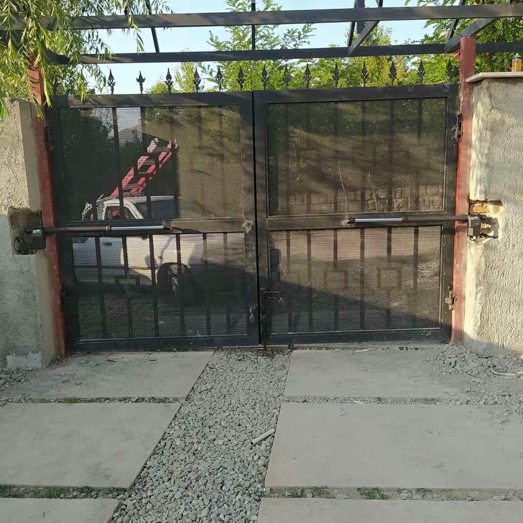 جک بازویی سفید کنار درب حیاط جک بازویی سفید کنار درب حیاط